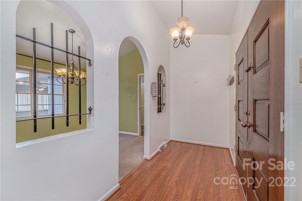 1446 McIlroy Road, Unit 8 Charlotte, NC 28212 - Photo 6 of 30 a view of a hallway with wooden floor and chandelier