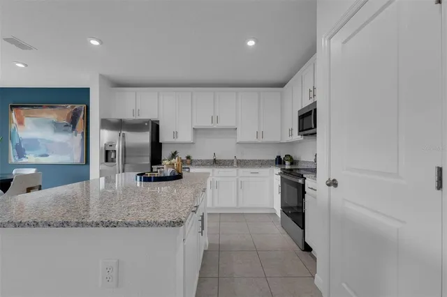 a kitchen with stainless steel appliances granite countertop a sink a stove a microwave and cabinets