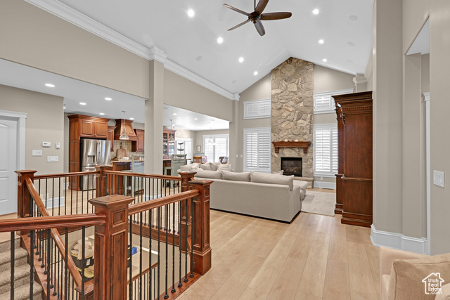 165 East 1550th South Perry, UT 84302 - Photo 14 of 26 Living room with light hardwood / wood-style floors, a healthy amount of sunlight, high vaulted ceiling, and a stone fireplace