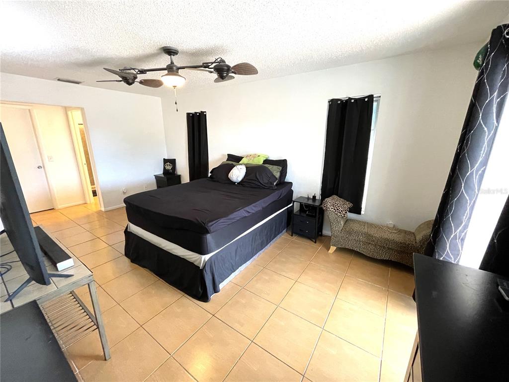 234 Shadow Street Northwest Port Charlotte, FL 33952 - Photo 27 of 48 a living room with a bed furniture and a flat tv screen