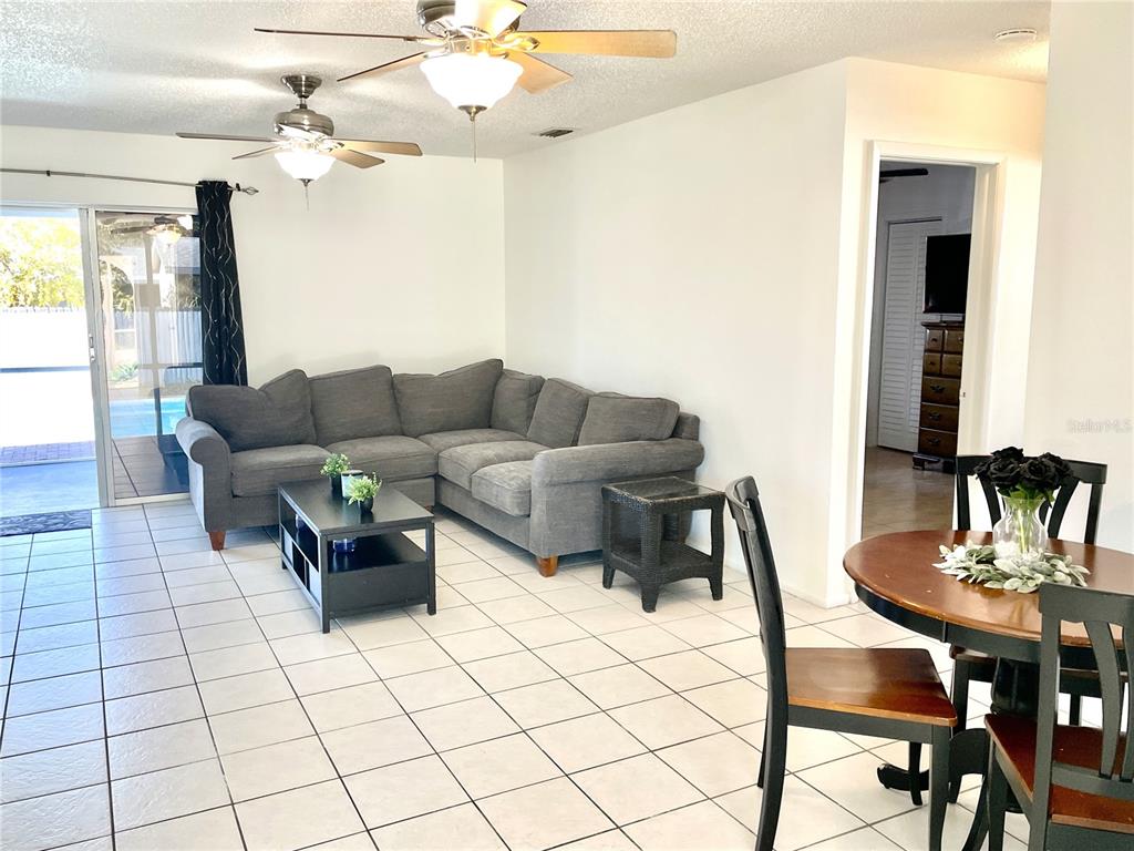 234 Shadow Street Northwest Port Charlotte, FL 33952 - Photo 6 of 48 a living room with furniture and a chandelier