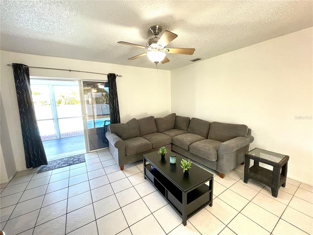234 Shadow Street Northwest Port Charlotte, FL 33952 - Photo 7 of 48 a living room with furniture and a chandelier