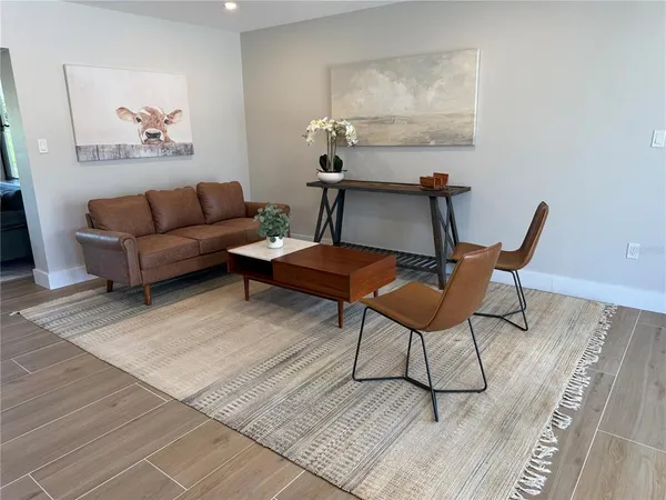 a living room with furniture a rug and a table