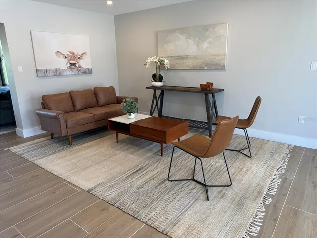 a living room with furniture a rug and a table