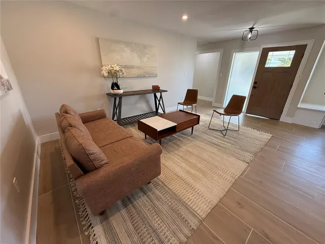 a living room with furniture and wooden floor