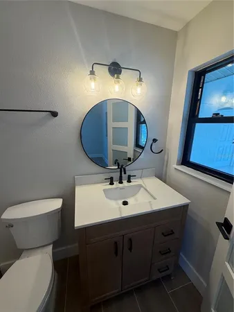 a bathroom with a toilet sink and mirror