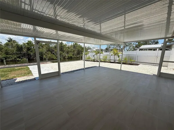 a view of empty room with wooden floor and windows