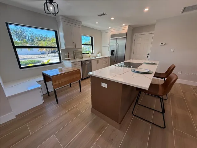 a room with a table chairs and a painting on the wall