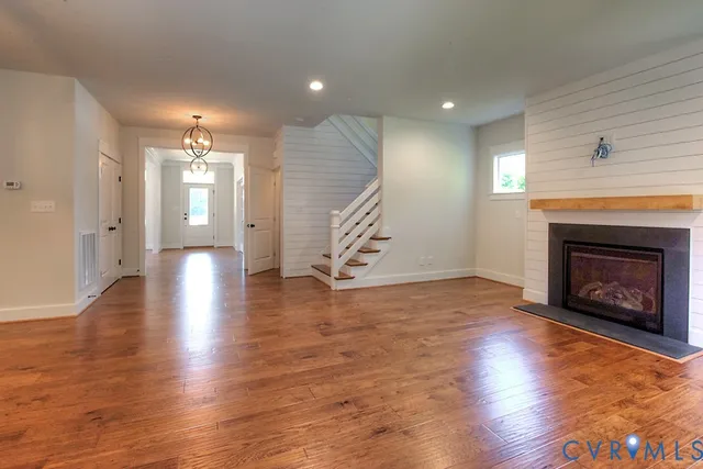 a view of a livingroom with wooden floor and a fireplace