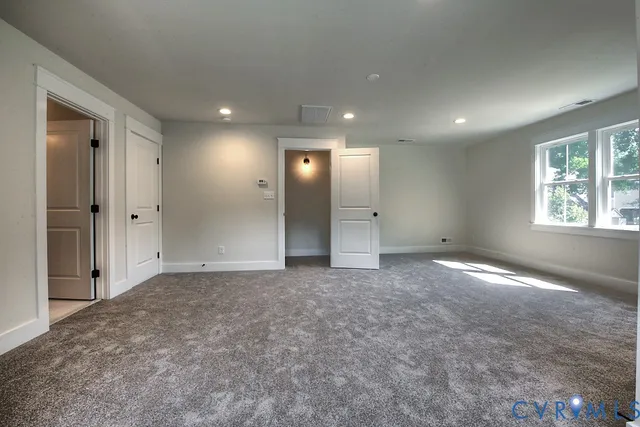 an empty room with windows and closet