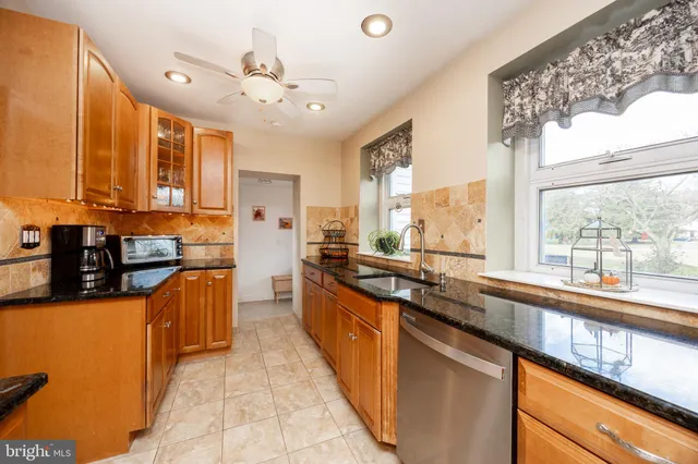 a large kitchen with stainless steel appliances granite countertop a sink and a counter
