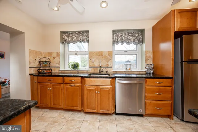 a kitchen with stainless steel appliances granite countertop a sink and a refrigerator