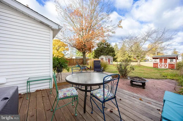a roof deck with table and chairs and wooden floor