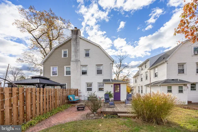 a view of a house with wooden fence and a yard