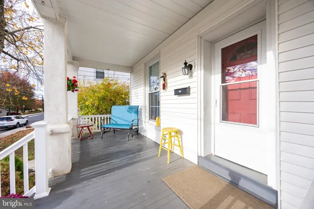 a view of a porch with chairs and couches next to a yard