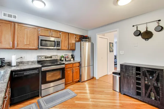 a kitchen with stainless steel appliances granite countertop a stove a sink and a refrigerator