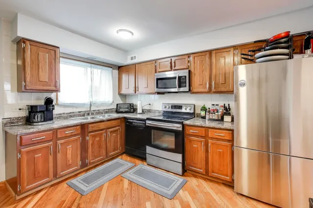 a kitchen with stainless steel appliances granite countertop a refrigerator sink and microwave