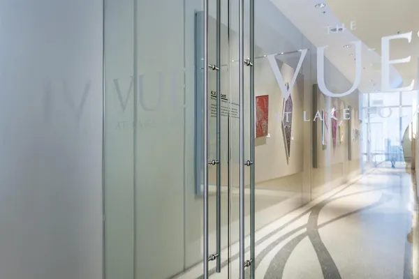 a view of a hallway with wooden floor and a bathroom