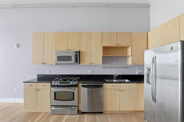 a kitchen with stainless steel appliances granite countertop a stove and a refrigerator