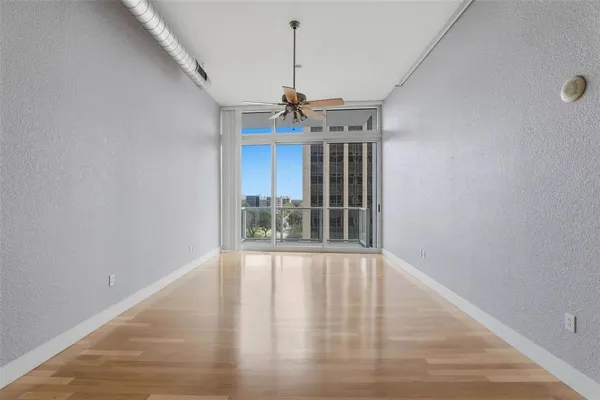 a view of a room with a ceiling fan and window