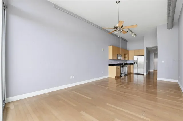 a view of a room with a ceiling fan and window