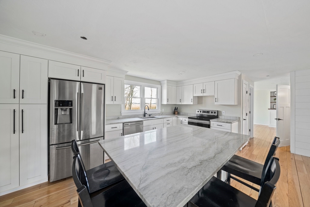 44 Jayna Way Marshfield, MA 02050 - Photo 7 of 27 a kitchen with kitchen island a refrigerator and wooden floor