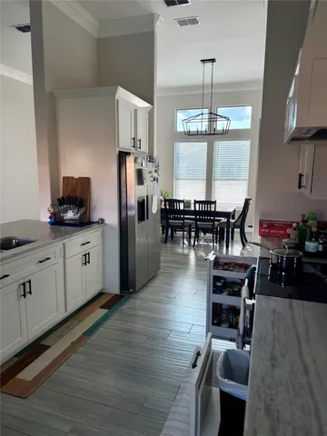 a kitchen with stainless steel appliances granite countertop a dining table chairs stove refrigerator and cabinets