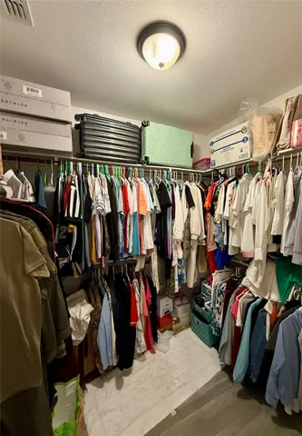 a view of walk in closet with clothes