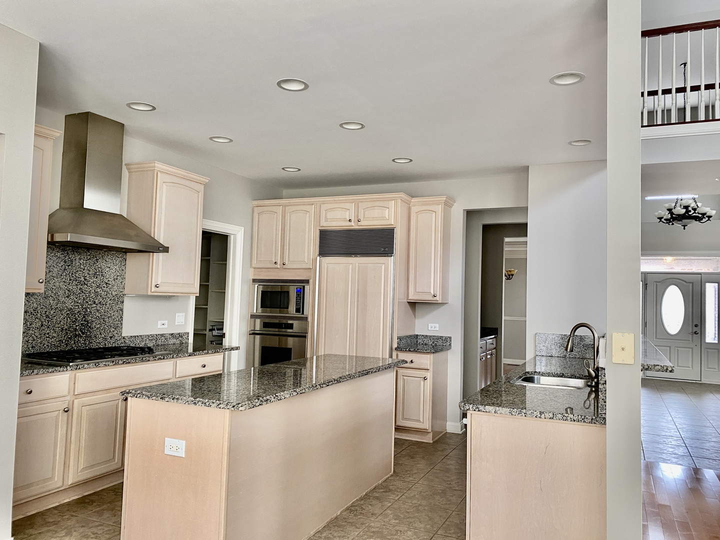 1686 Constitution Drive Glenview, IL 60026 - Photo 7 of 22 a kitchen with stainless steel appliances granite countertop a stove top oven a sink a refrigerator and white cabinets with wooden floor