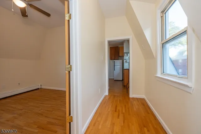 a view of a hallway with wooden floor and staircase
