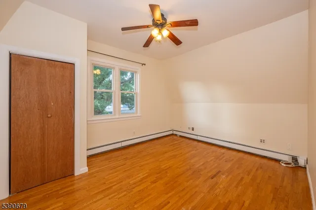 an empty room with a window and a ceiling fan