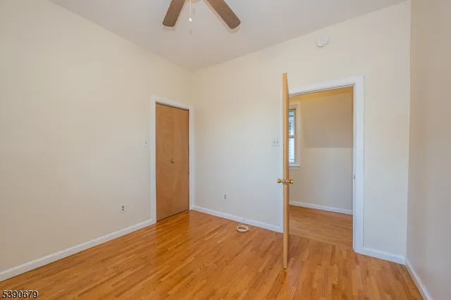 an empty room with wooden floor and window