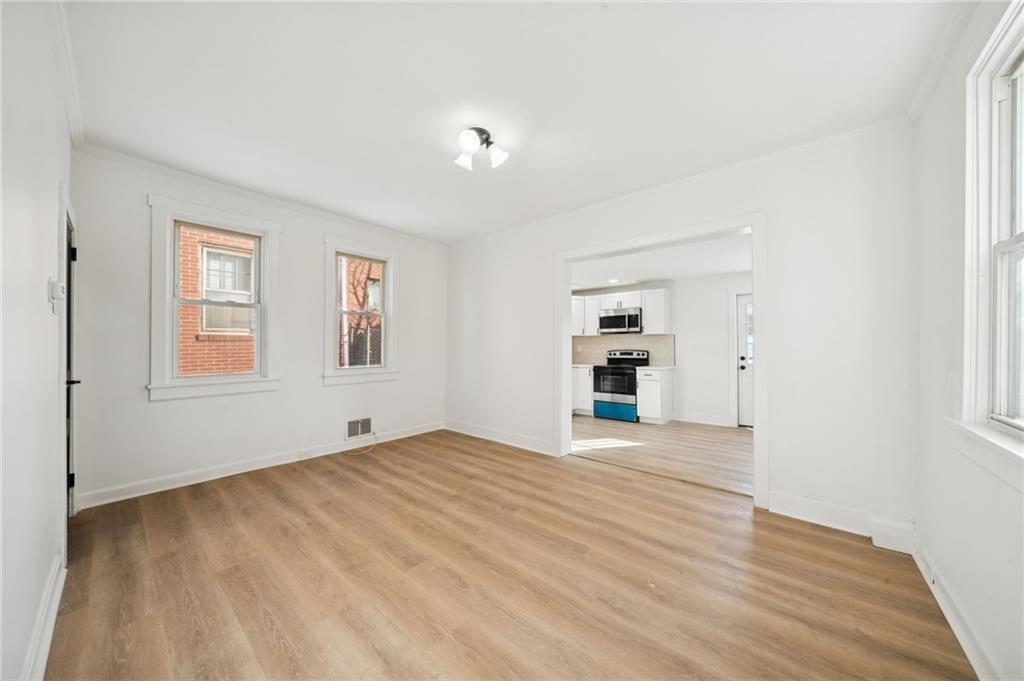 216 Whipple Street Pittsburgh, PA 15218 - Photo 11 of 29 a view of an empty room with a window and wooden floor