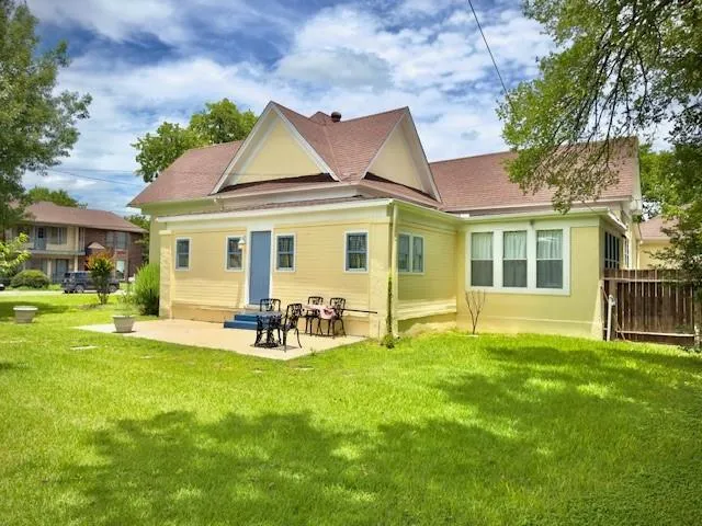 a view of a house with a backyard and a large tree