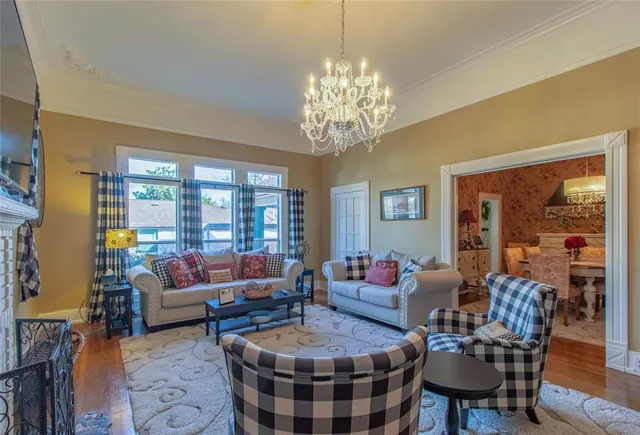 a living room with furniture chandelier and a large window