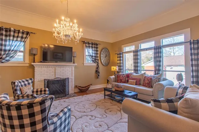 a living room with furniture a fireplace and a chandelier