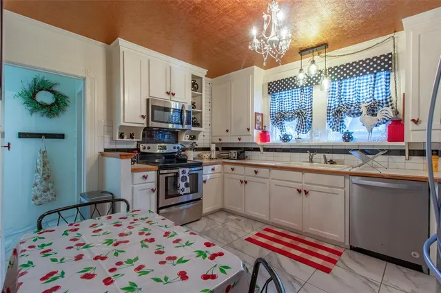 a kitchen that has a lot of cabinets in it and appliances