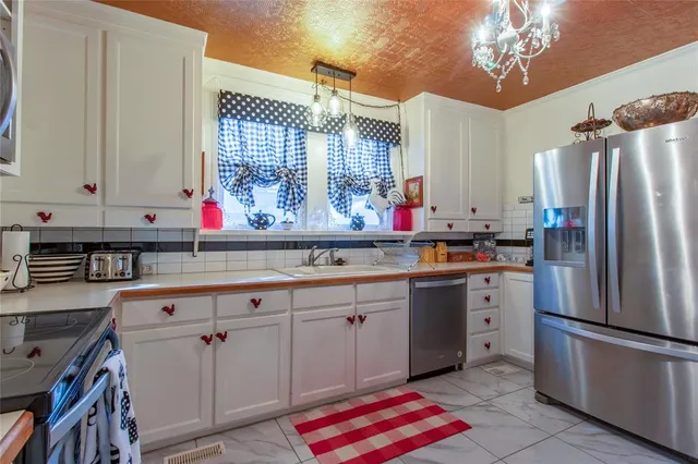 a kitchen with stainless steel appliances a sink cabinets and wooden floor