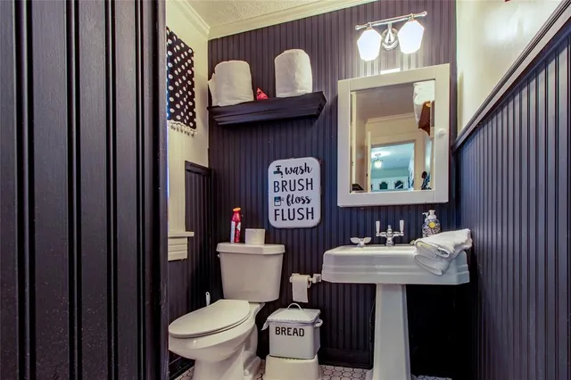 a bathroom with a toilet a sink and mirror