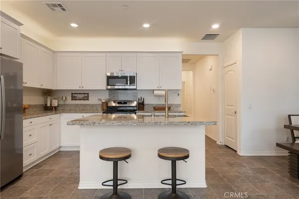 a kitchen with granite countertop a sink stove and cabinets