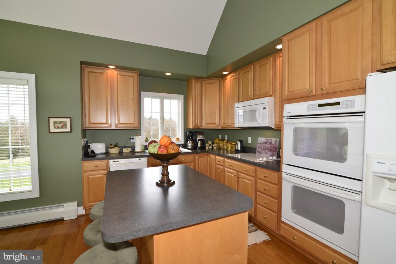 3056 Swift Shoals Road Boyce, VA 22620 - Photo 9 of 29 a kitchen with stainless steel appliances granite countertop a refrigerator a stove top oven a sink dishwasher and cabinets with wooden floor