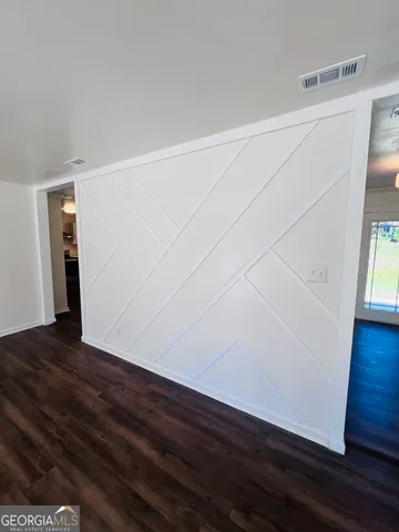 a view of an empty room with wooden floor