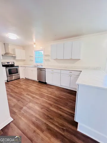 a kitchen with granite countertop a stove and white cabinets