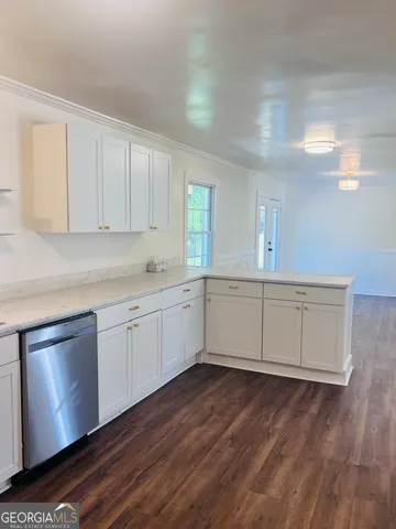 a kitchen with a sink cabinets and wooden floor