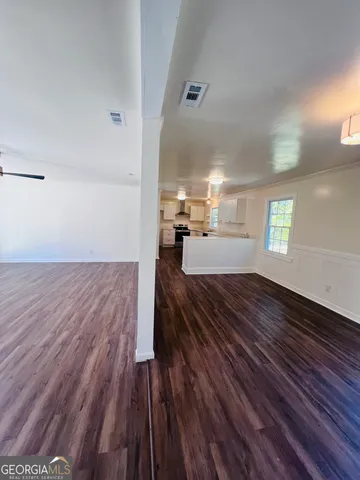 a view of empty room with wooden floor