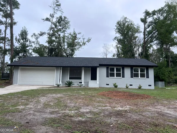 a front view of a house with yard and trees