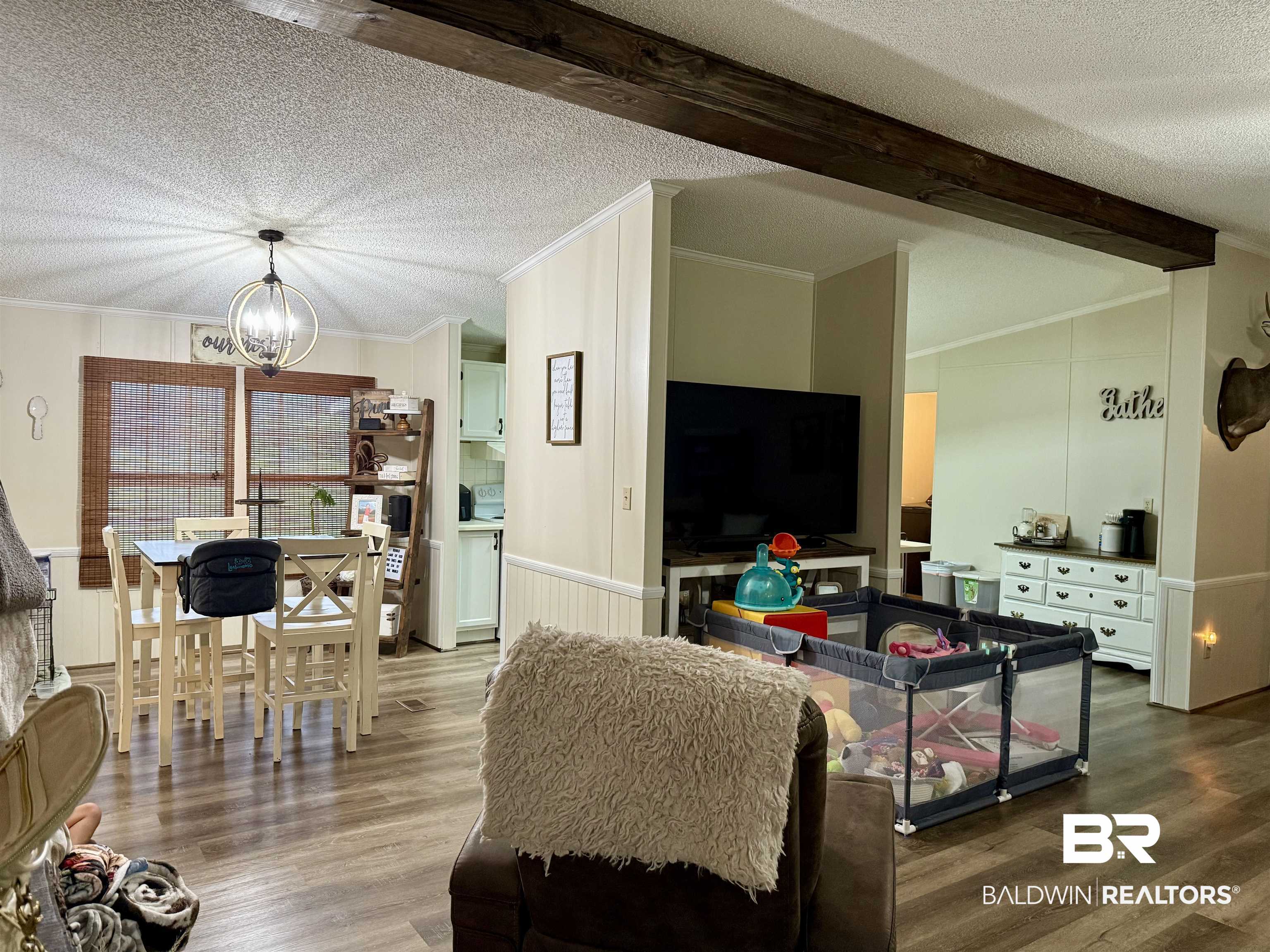 7577 Ridge Road Brewton, AL 36426 - Photo 5 of 24 Living area featuring ornamental molding, wood finished floors, a chandelier, a textured ceiling, and beam ceiling