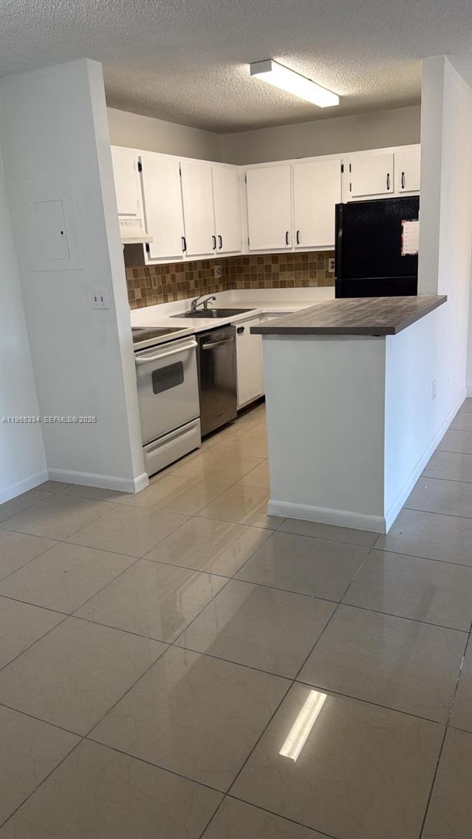 15620 Southwest 80th Street, Unit H203 Miami, FL 33193 - Photo 2 of 11 a kitchen with stainless steel appliances a stove a sink and a microwave