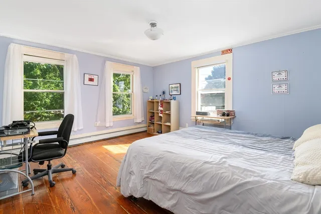 a bedroom with a bed and large windows