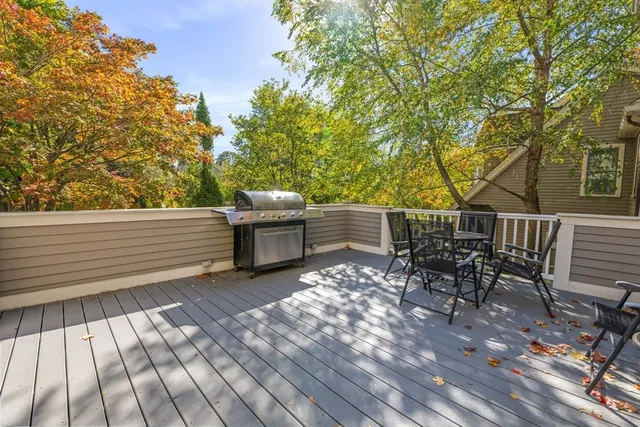 a view of a patio with table and chairs with wooden floor and fence